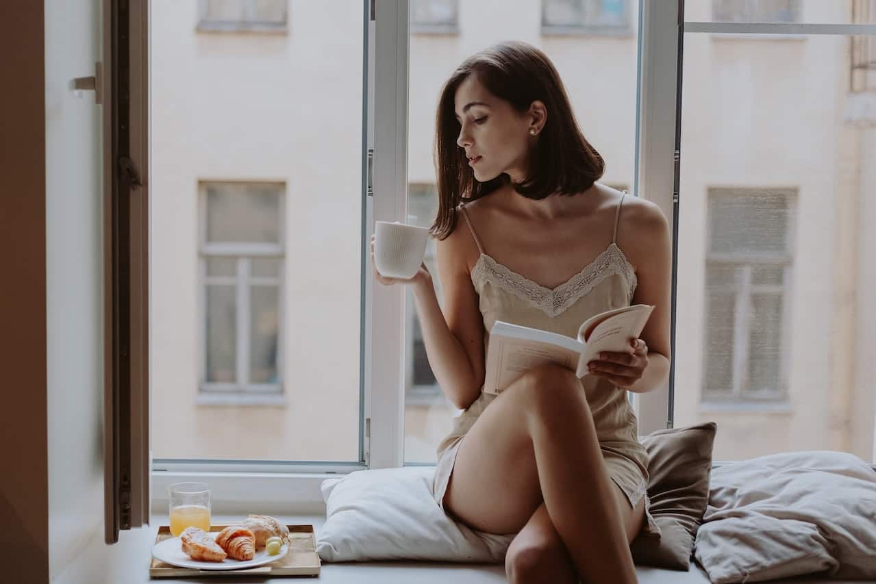mujer sensual leyendo en una ventana